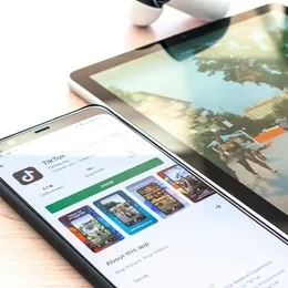 Eine Wissenschaftlerin und ein Wissenschaftler arbeiten hinter einer Glasfassade und mischen Chemikalien mit Großgeräten.