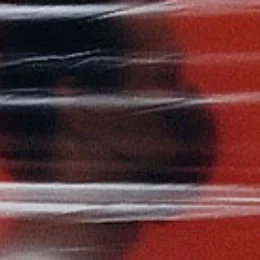 Eine Wissenschaftlerin und ein Wissenschaftler arbeiten hinter einer Glasfassade und mischen Chemikalien mit Großgeräten.