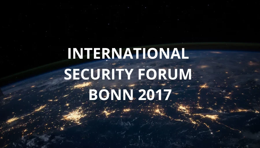 Eine Wissenschaftlerin und ein Wissenschaftler arbeiten hinter einer Glasfassade und mischen Chemikalien mit Großgeräten.